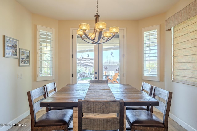 dining room featuring an inviting chandelier, hardwood / wood-style floors, and french doors