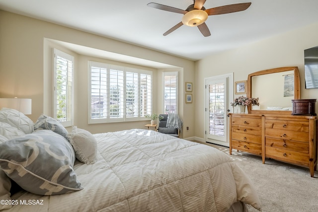 bedroom with ceiling fan, access to exterior, carpet floors, and multiple windows