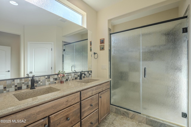 bathroom with vanity, a shower with door, and backsplash