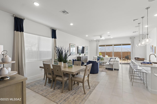 dining space featuring sink and light tile patterned flooring