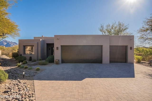 pueblo-style house featuring a mountain view and a garage