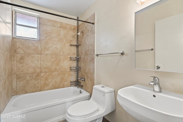 full bathroom with tiled shower / bath combo, sink, and toilet