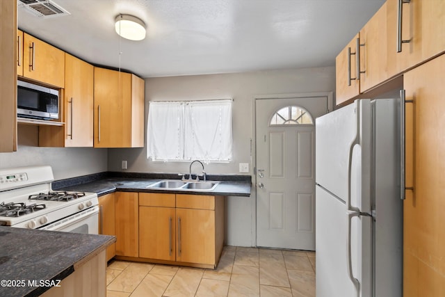 kitchen with light tile patterned flooring, white appliances, and sink