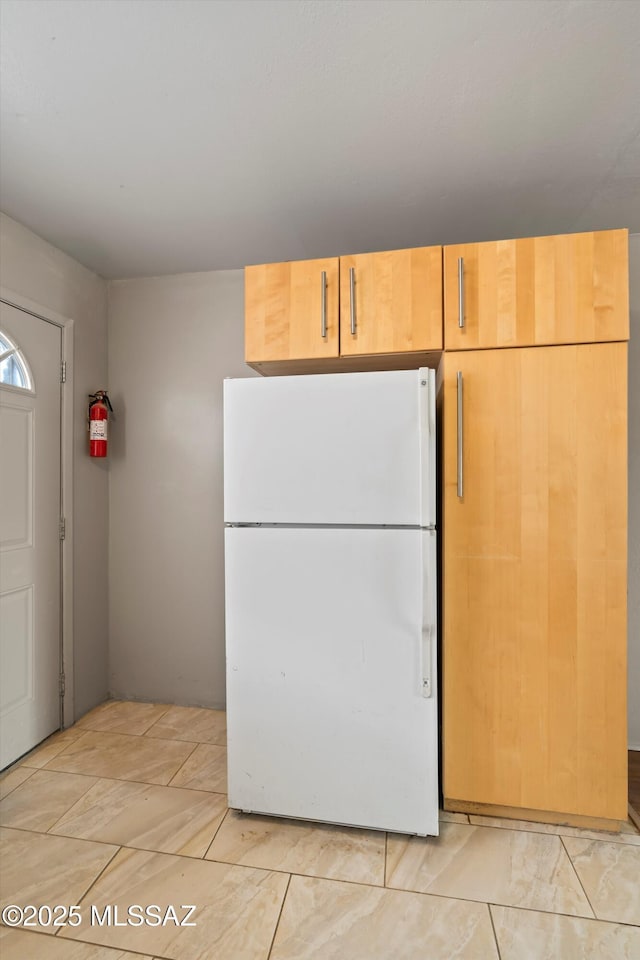 kitchen featuring white fridge and light brown cabinets