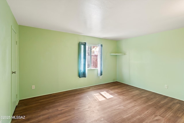 spare room featuring wood-type flooring