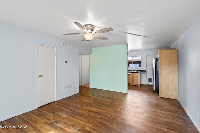 unfurnished living room featuring ceiling fan, sink, and dark hardwood / wood-style floors