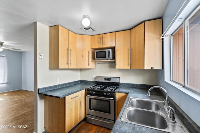 kitchen featuring dark wood-type flooring, light brown cabinetry, sink, appliances with stainless steel finishes, and ceiling fan