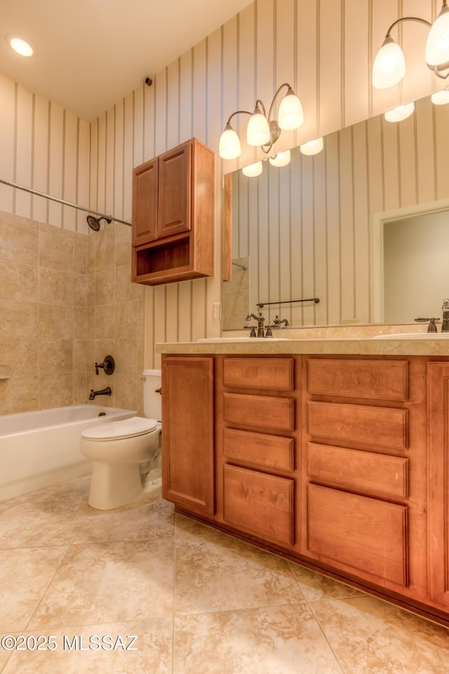 full bathroom featuring tiled shower / bath combo, toilet, and vanity