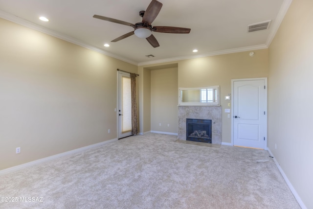 unfurnished living room featuring ceiling fan, crown molding, light carpet, and a tiled fireplace