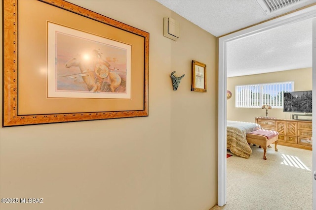 hallway featuring carpet floors and a textured ceiling