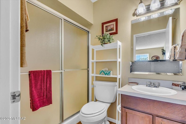 bathroom featuring vanity, an enclosed shower, and toilet