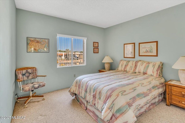 bedroom with light carpet and a textured ceiling