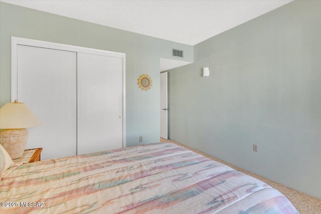 bedroom with a textured ceiling and a closet