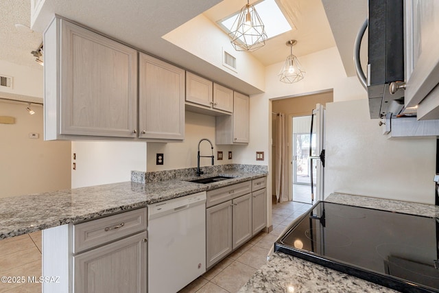 kitchen with white dishwasher, rail lighting, sink, pendant lighting, and light tile patterned flooring