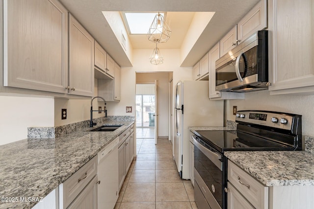 kitchen featuring hanging light fixtures, appliances with stainless steel finishes, sink, light stone counters, and light tile patterned flooring