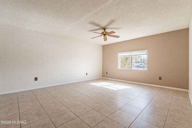 spare room featuring light tile patterned floors, a textured ceiling, brick wall, and ceiling fan