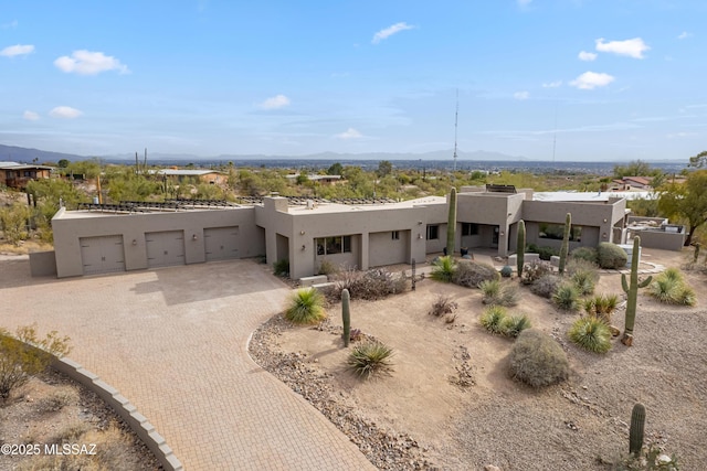 pueblo-style home featuring a mountain view and a garage