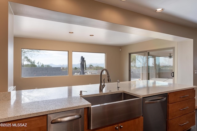 kitchen featuring light stone counters, sink, and dishwasher