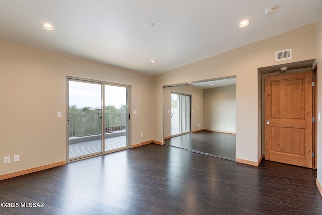 spare room featuring dark hardwood / wood-style floors and vaulted ceiling