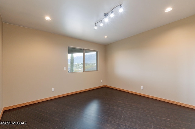 unfurnished room with dark wood-type flooring and track lighting