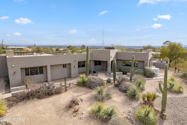 pueblo revival-style home featuring a patio area