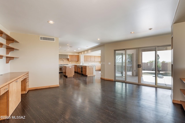 unfurnished living room with dark hardwood / wood-style flooring and sink