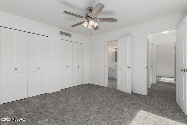 unfurnished bedroom featuring visible vents, two closets, baseboards, ceiling fan, and carpet flooring