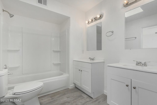 full bathroom with toilet, wood-type flooring, shower / washtub combination, and vanity