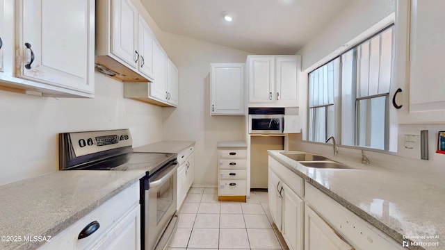 kitchen with light tile patterned floors, electric stove, white cabinets, light stone counters, and sink