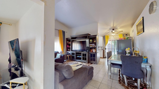 living room with ceiling fan, light tile patterned floors, and lofted ceiling