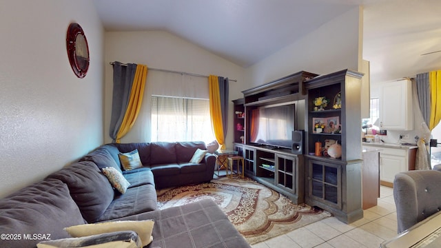 living room featuring ceiling fan, vaulted ceiling, and light tile patterned flooring