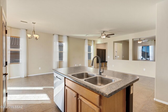 kitchen featuring decorative light fixtures, a center island with sink, sink, stainless steel appliances, and a chandelier