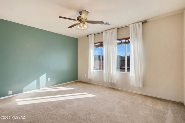 carpeted spare room featuring ceiling fan