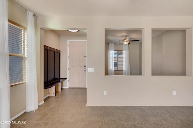 empty room featuring ceiling fan and a wealth of natural light