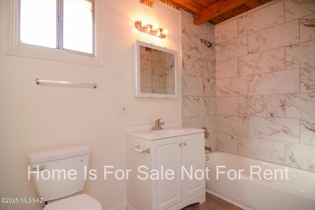 full bathroom featuring toilet, tiled shower / bath, vanity, and beamed ceiling