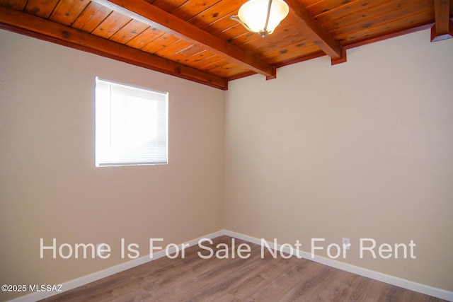 empty room featuring hardwood / wood-style flooring, wooden ceiling, and beamed ceiling