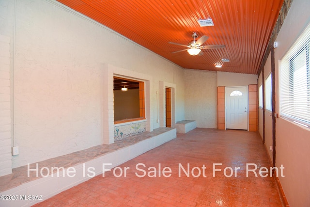 unfurnished sunroom with wooden ceiling and ceiling fan