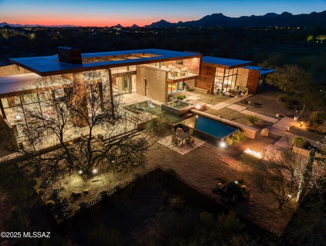 back of house featuring a patio and an in ground hot tub