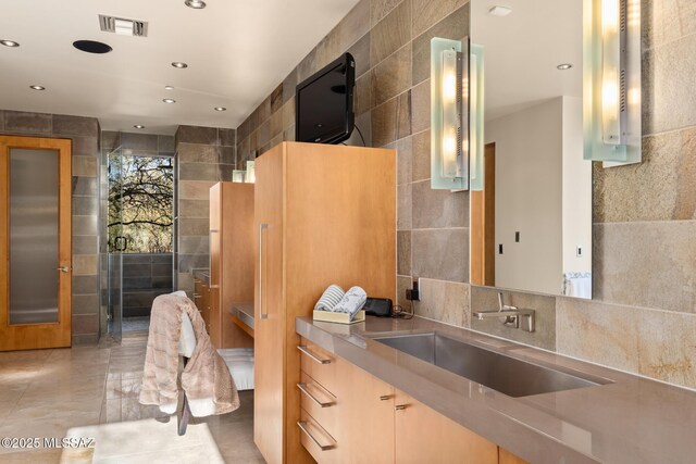 bathroom with tasteful backsplash, vanity, and tile walls