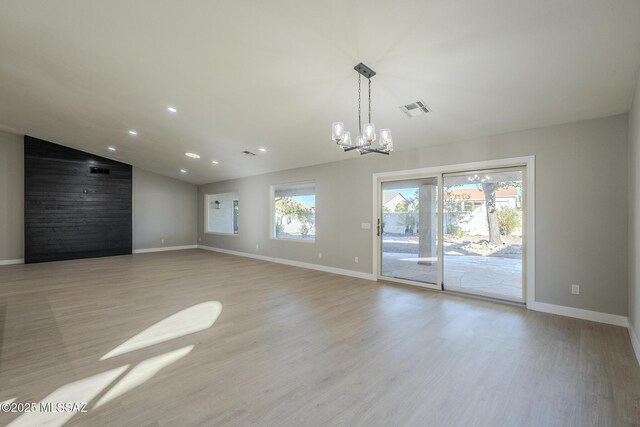 kitchen featuring hanging light fixtures, light wood-type flooring, stainless steel fridge with ice dispenser, an island with sink, and a chandelier