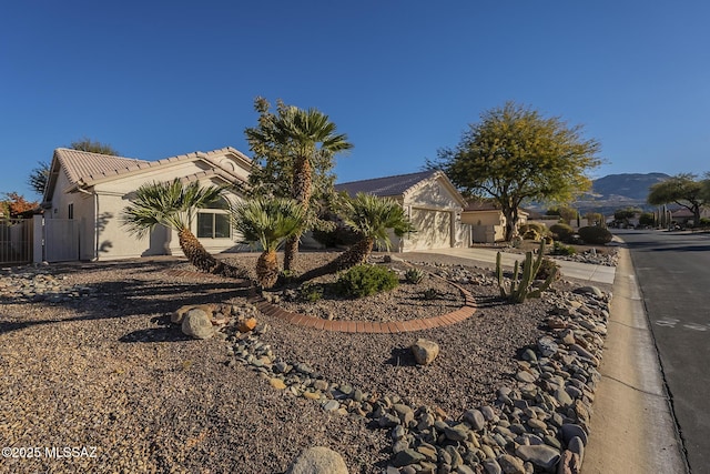 view of side of home with a garage and a mountain view