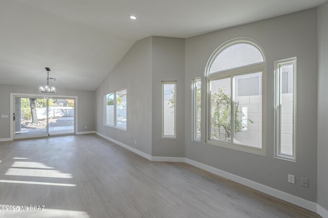 kitchen with vaulted ceiling, decorative backsplash, light hardwood / wood-style floors, and decorative light fixtures