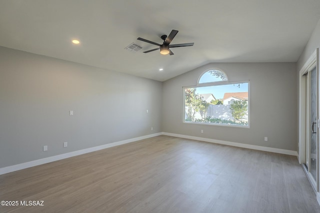 spare room featuring ceiling fan, vaulted ceiling, plenty of natural light, and light hardwood / wood-style floors