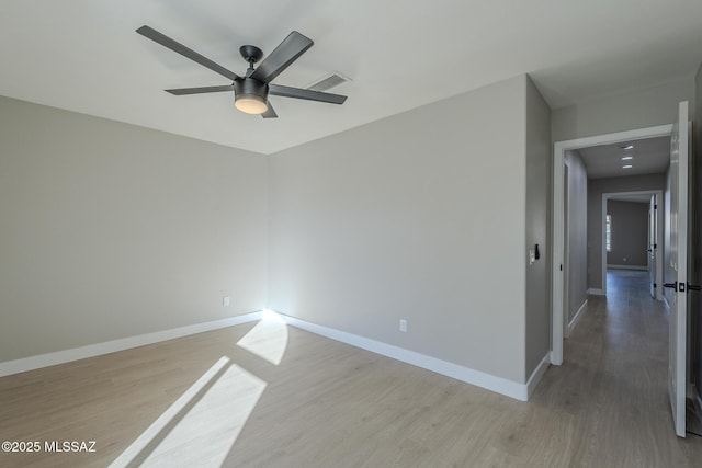 empty room with ceiling fan and light hardwood / wood-style flooring