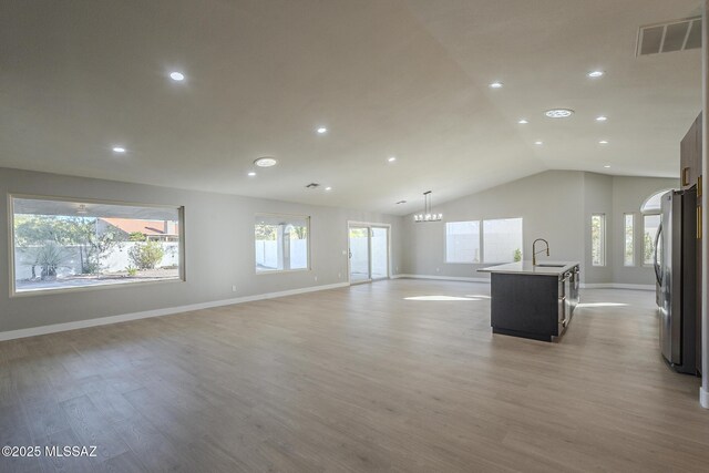 empty room featuring light hardwood / wood-style flooring and vaulted ceiling