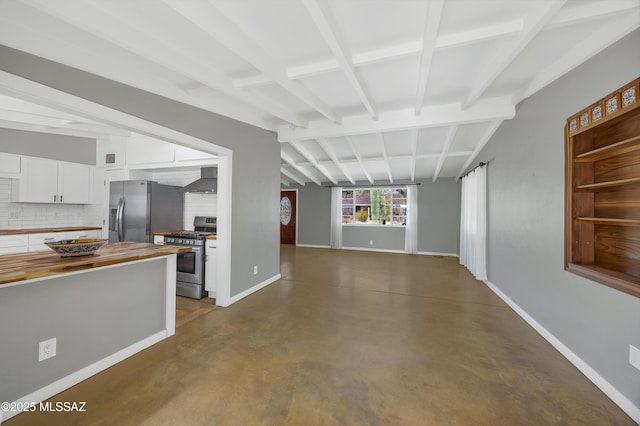 interior space featuring lofted ceiling with beams and concrete flooring