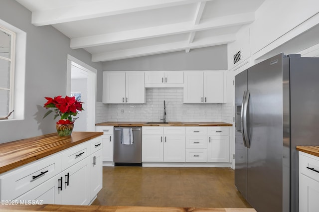 kitchen with backsplash, wooden counters, sink, appliances with stainless steel finishes, and white cabinets