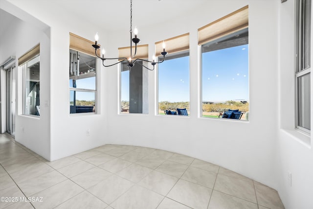 tiled spare room with a notable chandelier