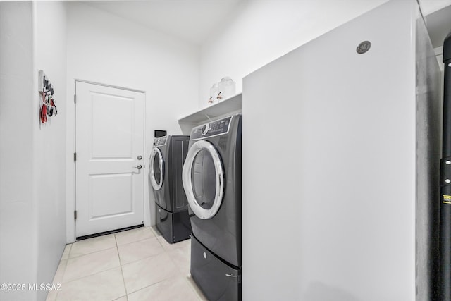 washroom with washing machine and dryer, laundry area, and light tile patterned flooring