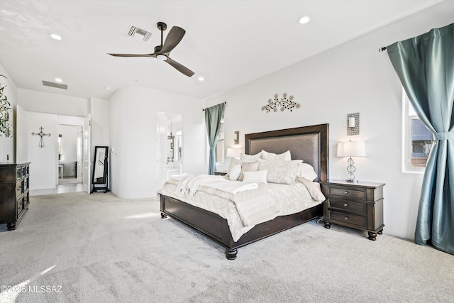 bedroom featuring ensuite bathroom, light carpet, and ceiling fan